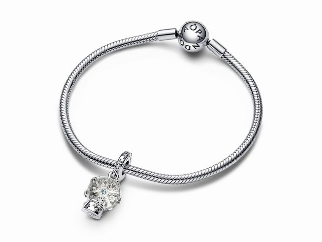 Silberner Pandora Charm mit der Artikelnummer 792369C01 in Form einer Schneeflocken Schneekugel, elegant an einem feinen Armband befestigt, ideal für Schmuckliebhaber.